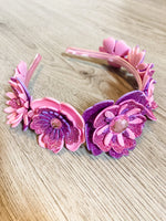 Pink and purple floral headband on a wooden surface