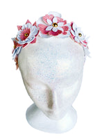 Floral headband with pink and white flowers on a mannequin head against a white background