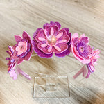 Pink and purple flower headband on a wooden surface