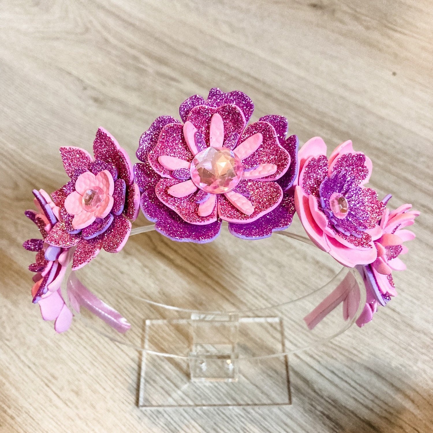 Pink and purple flower headband on a wooden surface