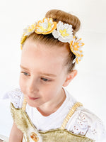 Young girl wearing a decorative headband with flowers on a white background