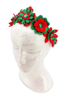 Red and green floral headband on a mannequin head with a white background