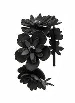 Black floral headband with layers of petals and diamanté centres on a white background