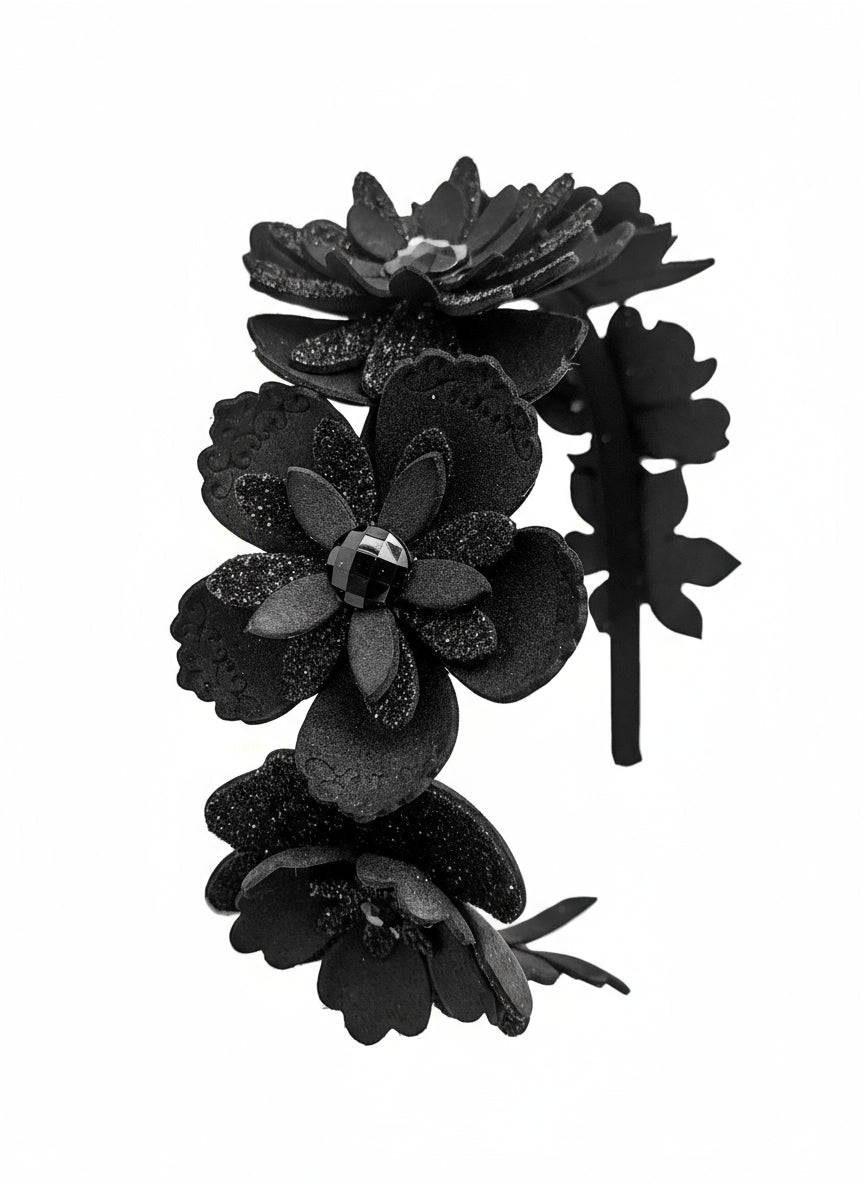 Black floral headband with layers of petals and diamanté centres on a white background