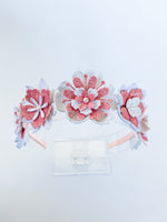 Floral headband with pink and white flowers on a light gray background