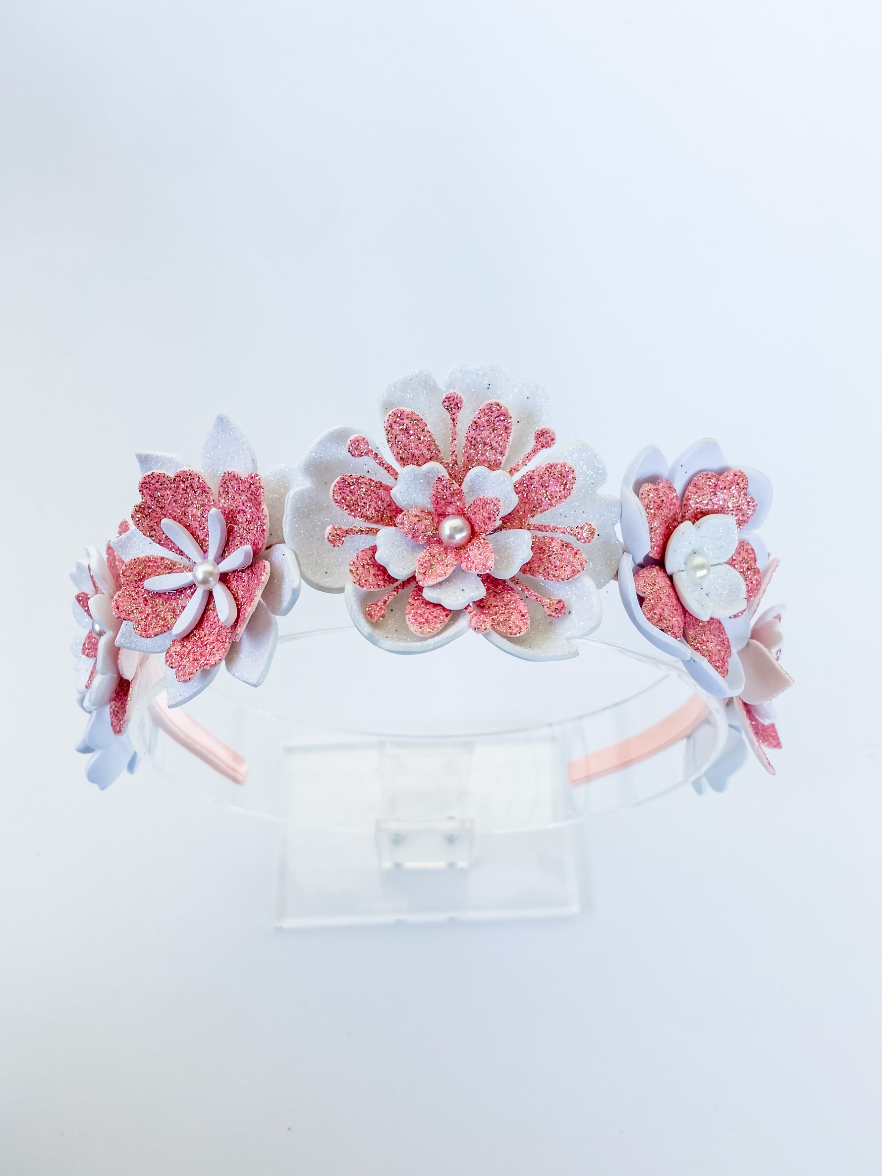Floral headband with pink and white flowers on a light gray background