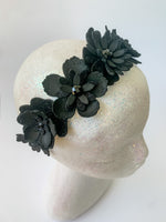 Black floral headband on a mannequin head with a white background