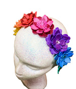 Colorful flower headband on a mannequin head against a wooden background