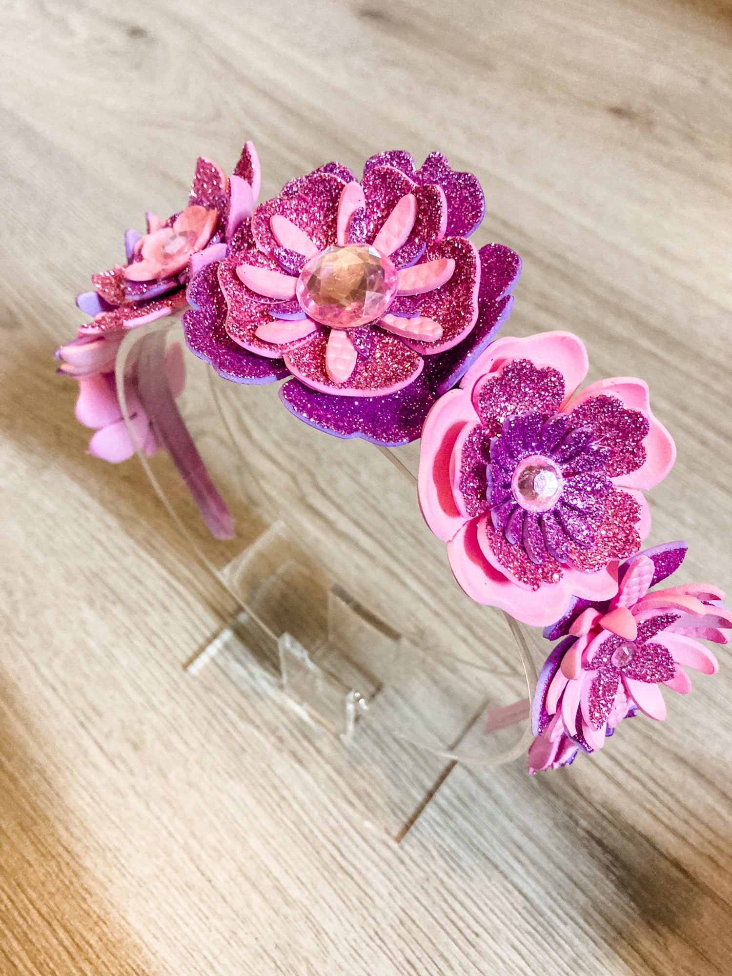 Pink and purple floral headbands on a wooden surface