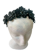 Black floral headband on a mannequin head with a white background