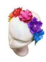 Colorful flower headbands on a mannequin head with a wooden background