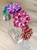 Colorful flower-shaped hair accessories on a wooden surface