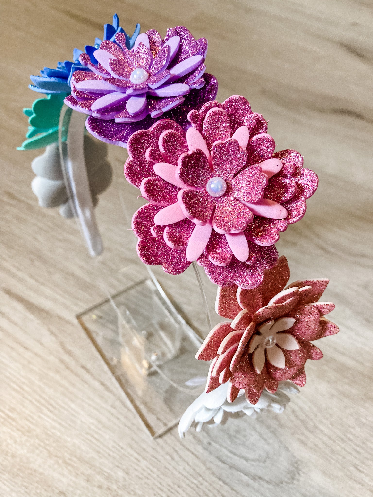 Colorful flower-shaped hair accessories on a wooden surface