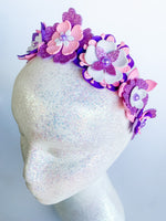 Decorative headband with flowers and butterflies on a mannequin head against a white background