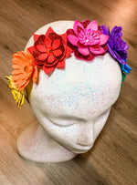 Colorful flower headband on a mannequin head with a wooden background