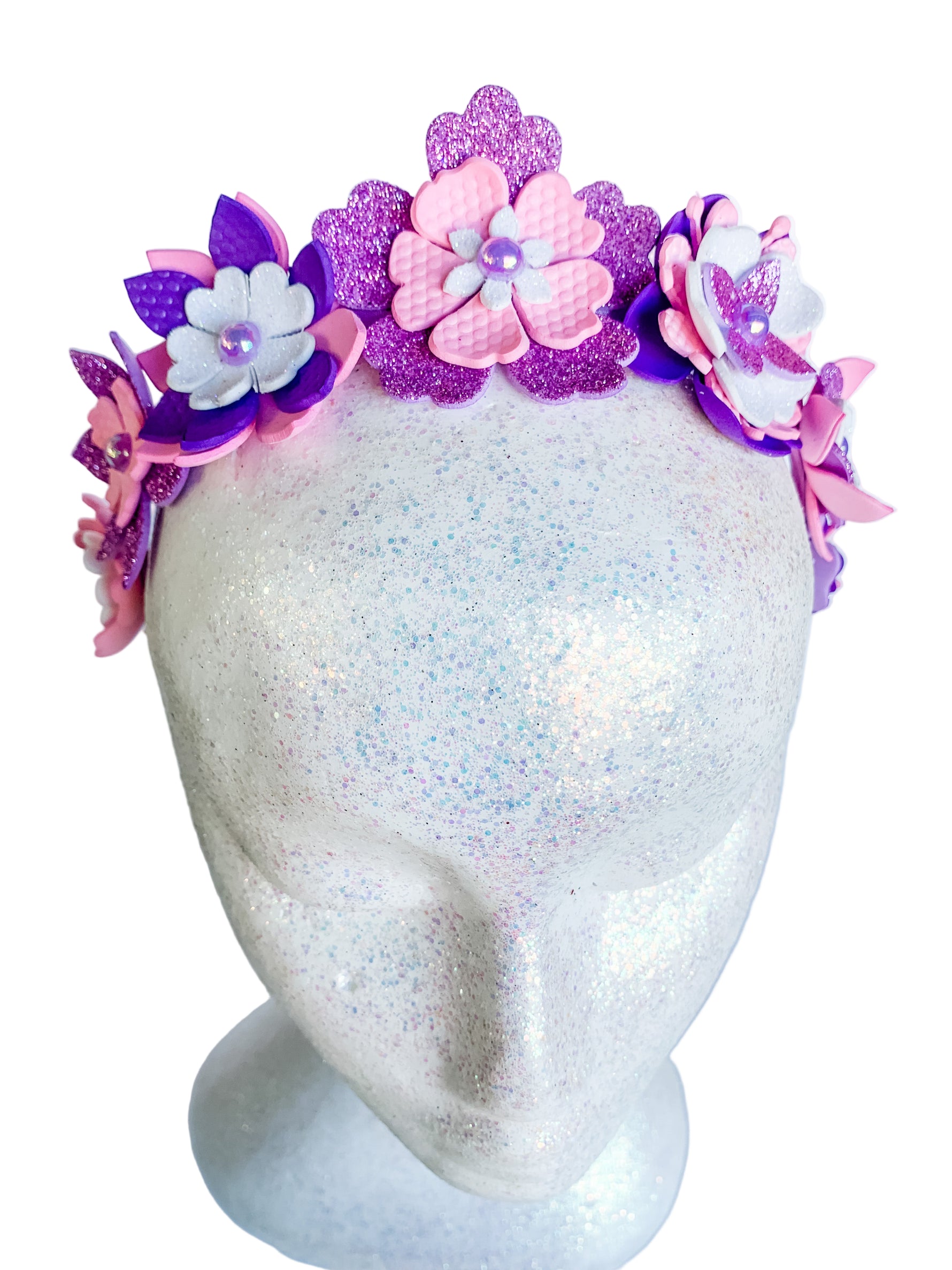 Floral headband with pink and purple flowers on a mannequin head against a white background