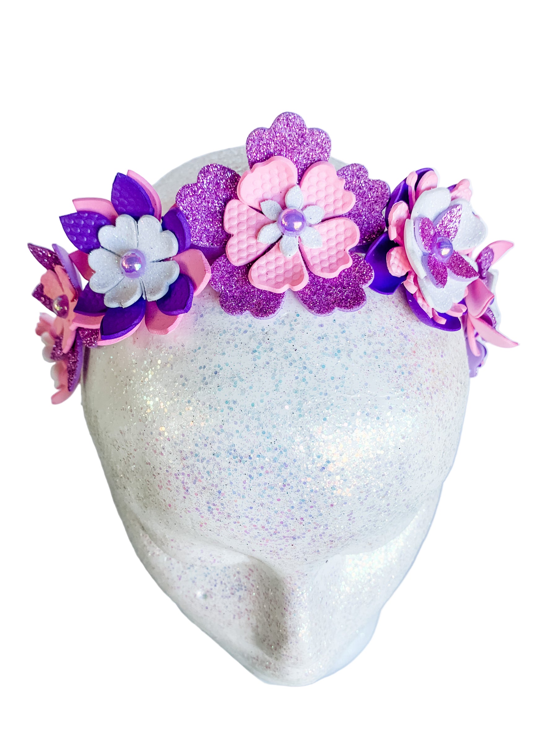 Decorative headband with pink and purple flowers on a mannequin head.