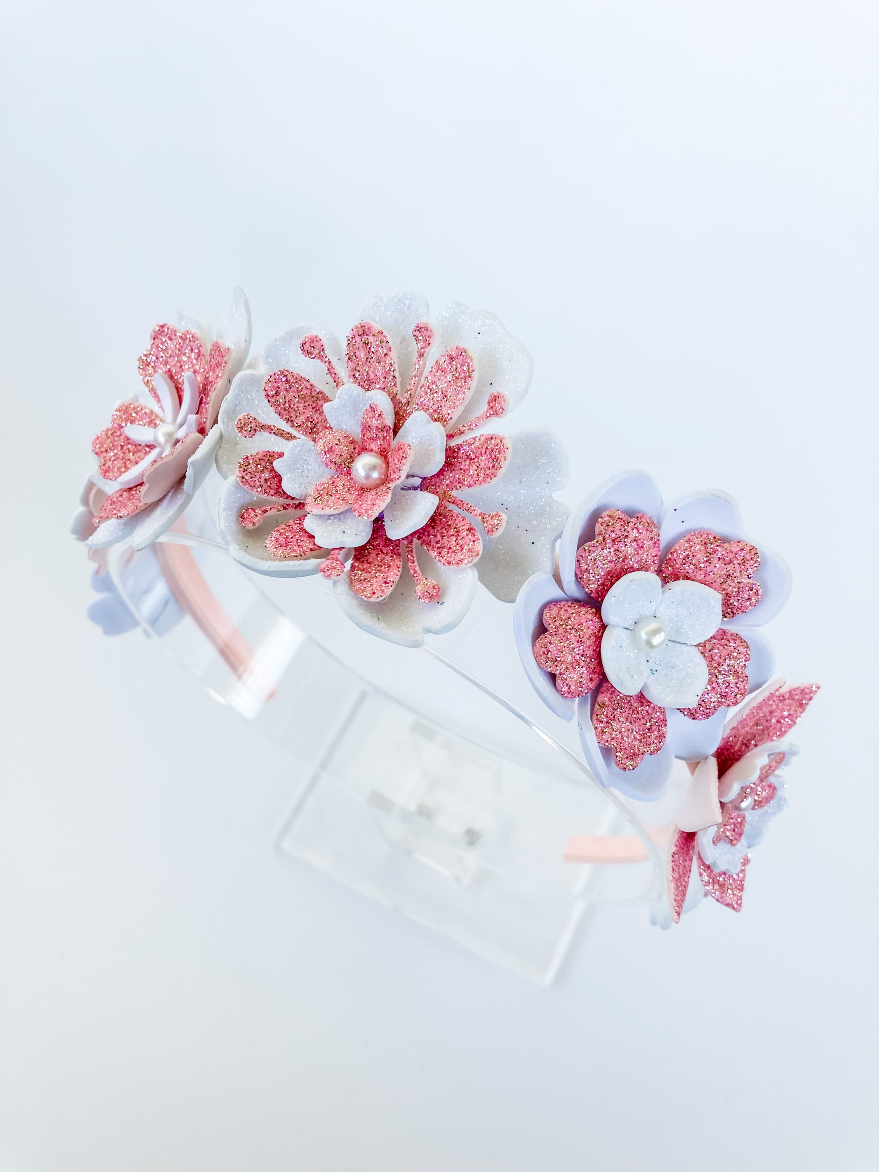 Set of pink and white floral hair accessories on a light background