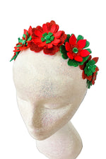Red and green floral headband on a mannequin head against a white background