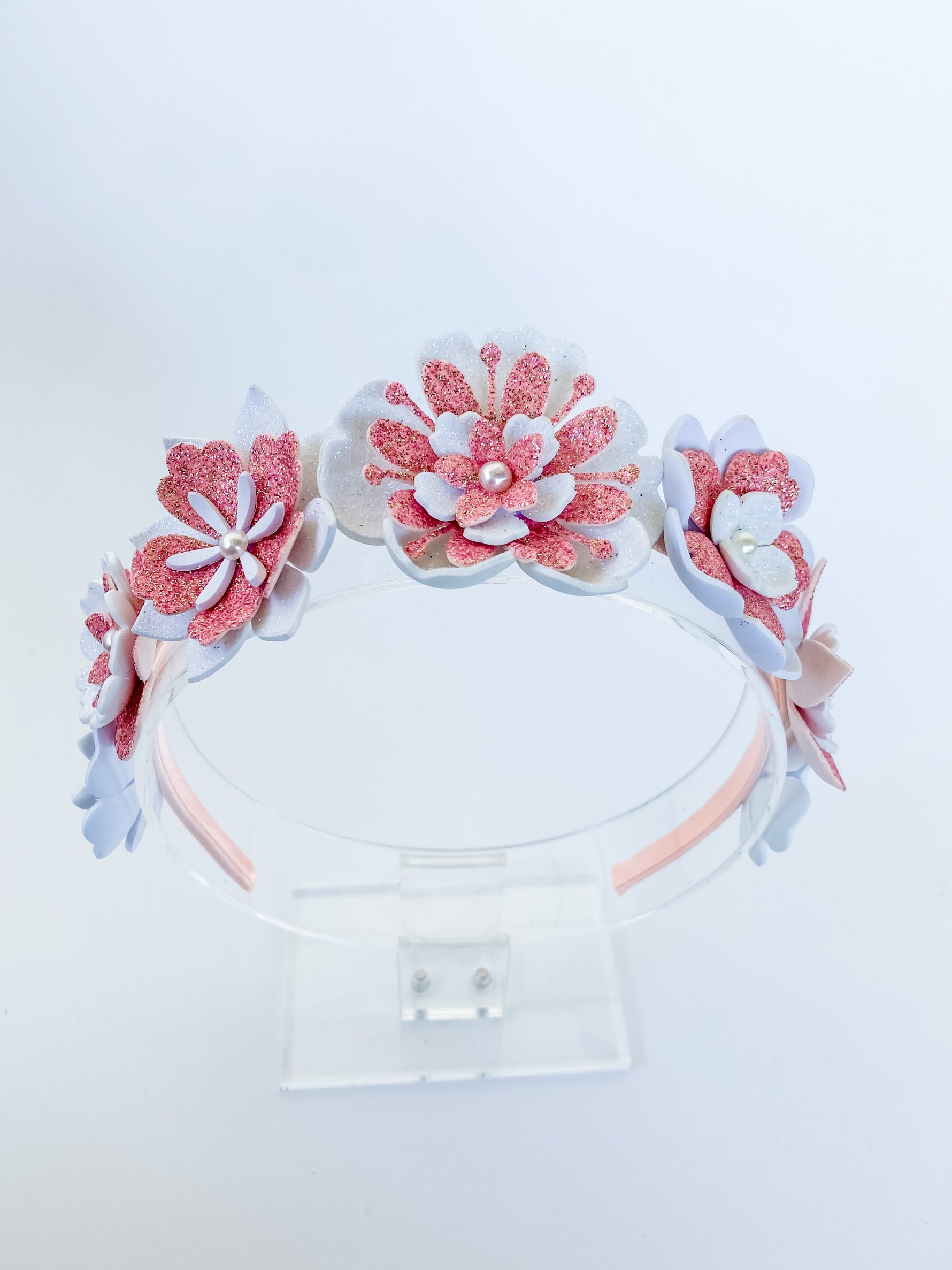 Decorative headband with pink and white floral designs on a white background