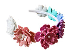 Colorful flower headbands on a wooden surface