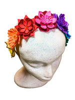 Mannequin head with colorful floral headband on a wooden surface