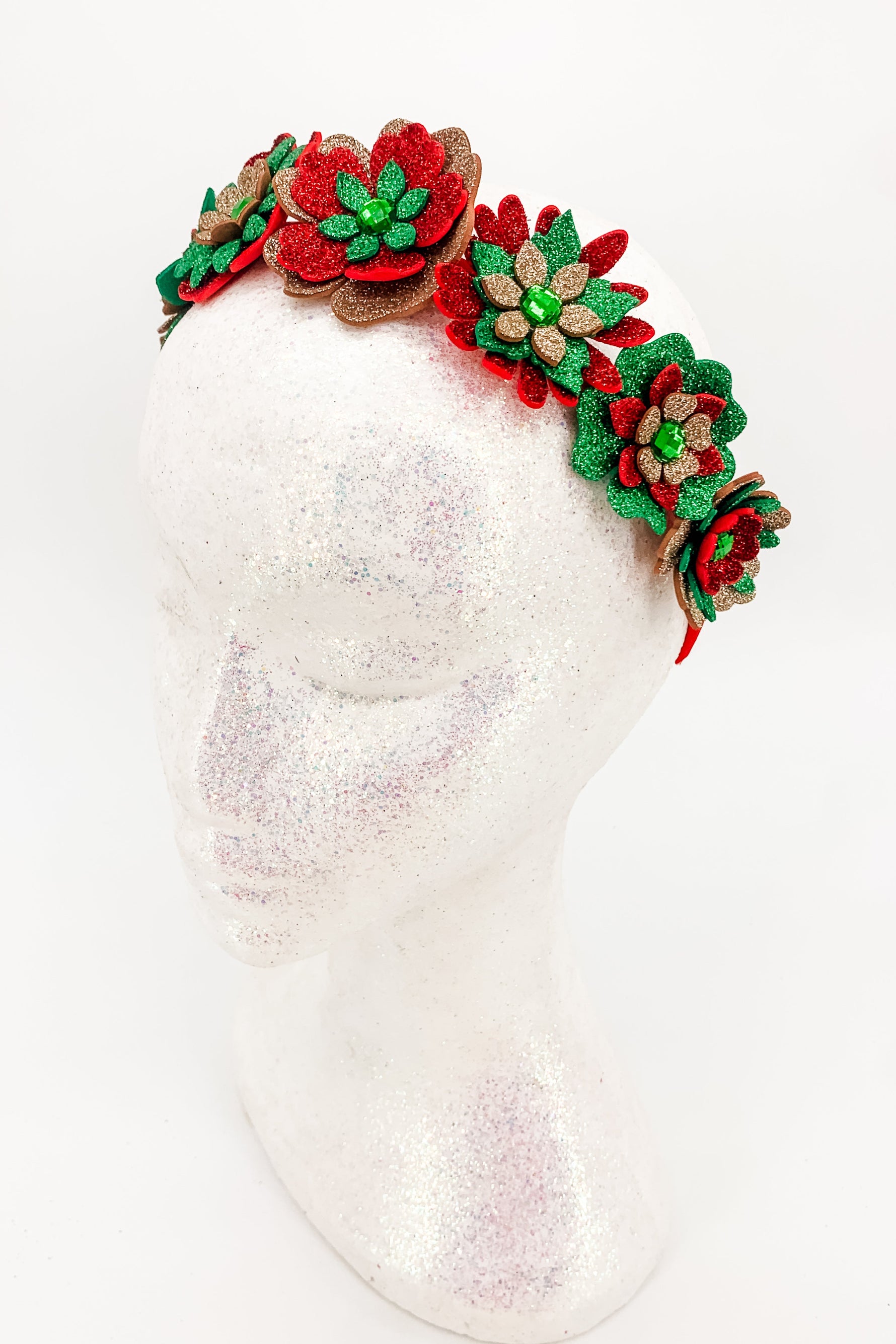 Decorative red, gold and green floral headband on a white background