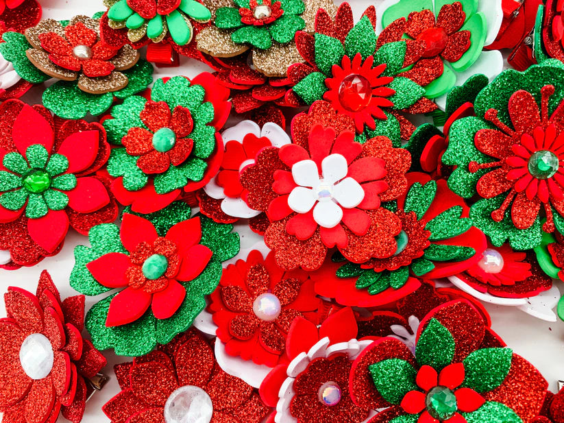 A mixture of red, white, green and gold flower hair clips with rhinestone centres