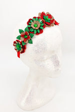 Decorative headband with red, green, and brown flowers on a white background