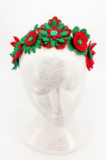 Red and green floral headband on a mannequin head against a white background