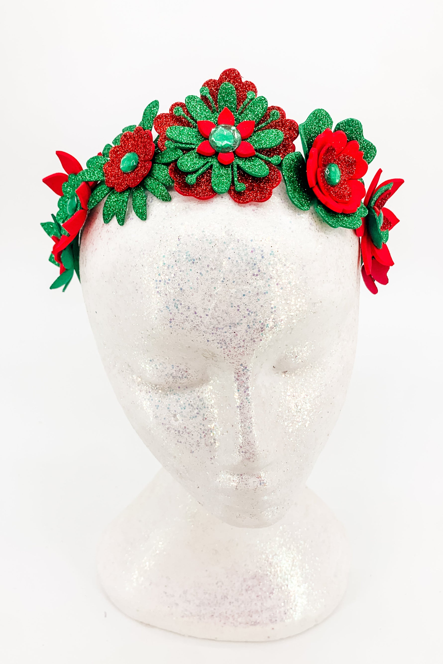 Red and green floral headband on a mannequin head against a white background